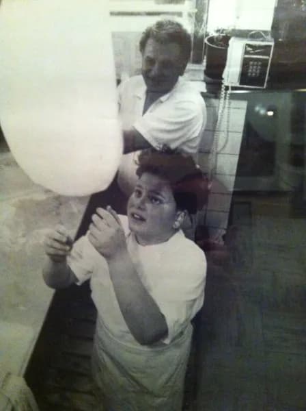 A young member of the family tossing dough, photographed in black and white