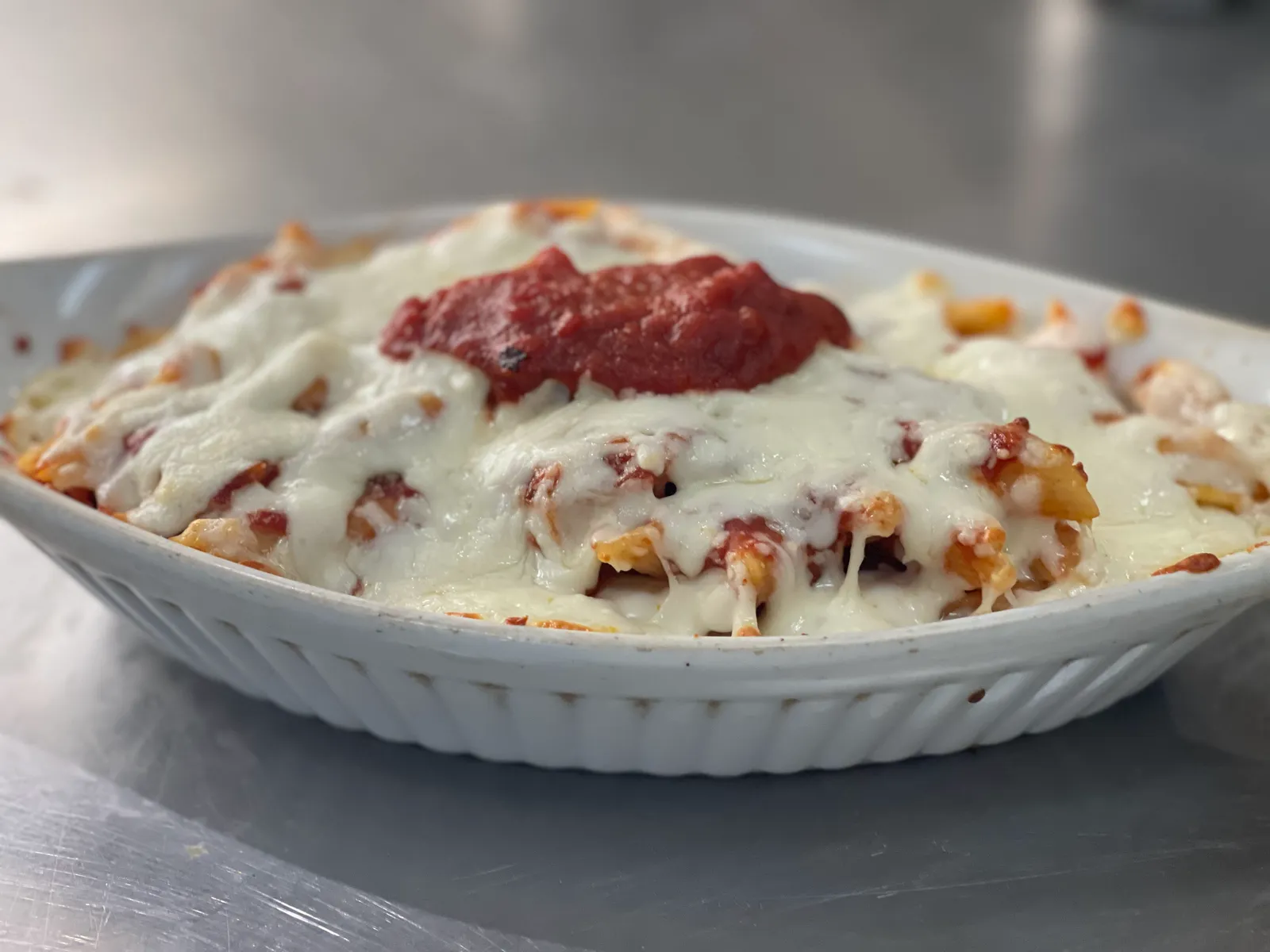 Lasagna al Forno, baked under melted cheese with a spoon of sauce on top