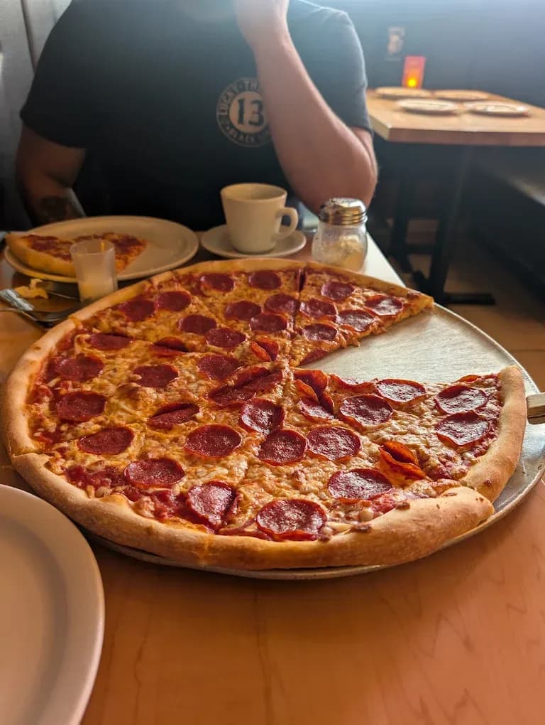 A large double pepperoni pizza on a metal tray