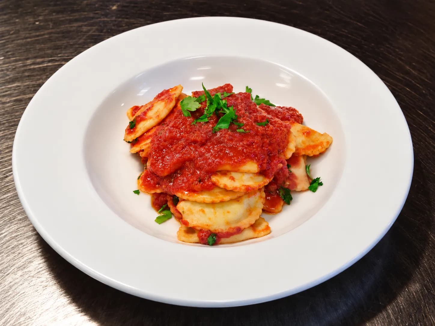 Ravioli Pomodoro in red sauce, finished with fresh parsley