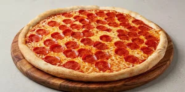 A New York, New York pizza — double dry-cured pepperoni on the pan at the table
