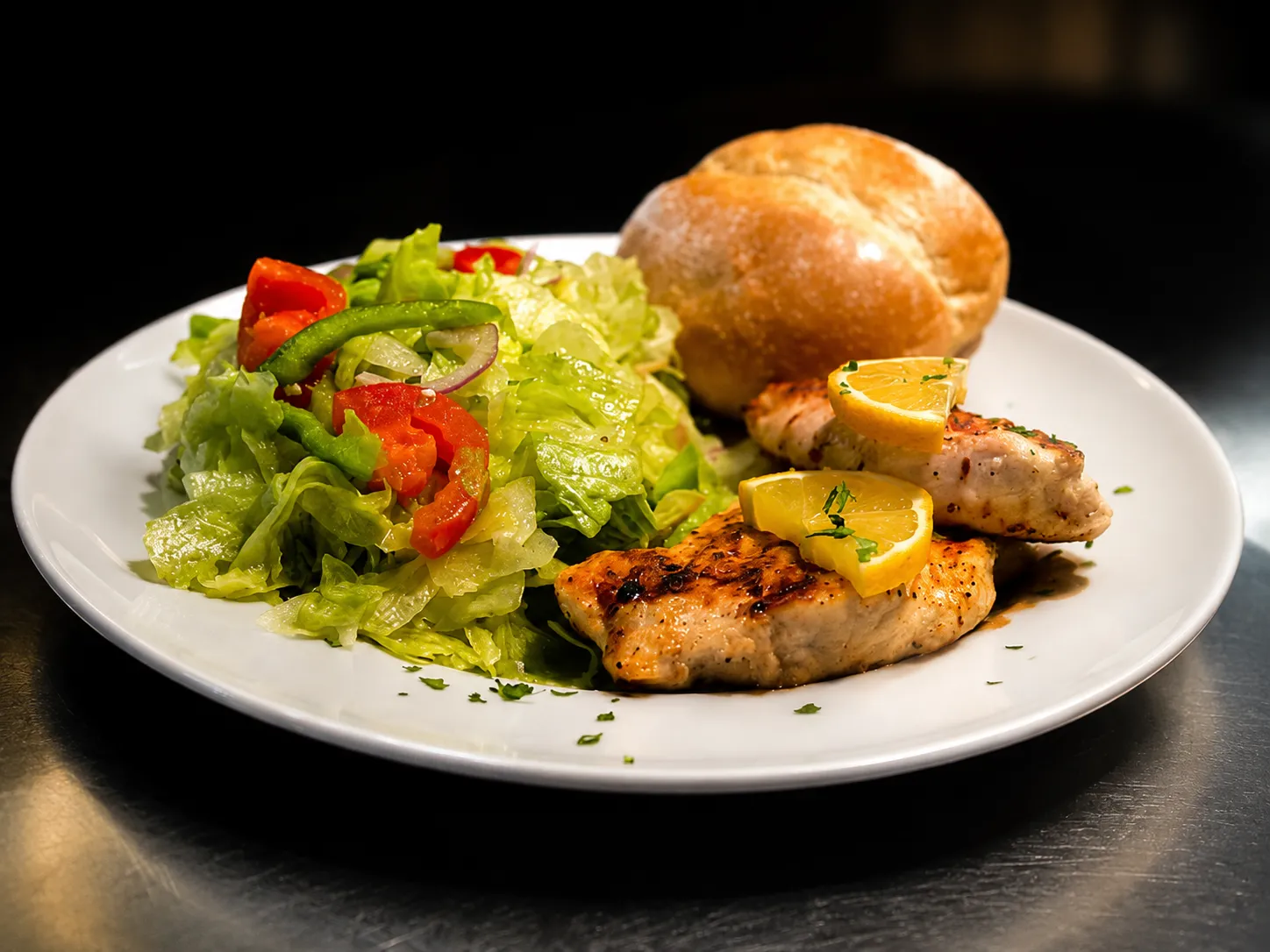 Grilled chicken breast with lemon, a green salad and a fresh Italian roll
